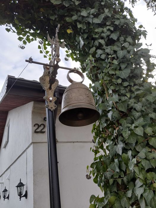 stary dzwon mosiężny , wiszący na stelażu