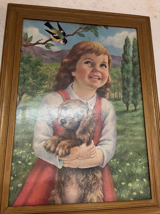Quadro decorativo antigo retratando uma criança com um cão, num estilo artístico popular de meados do século XX.