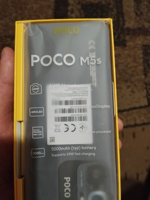 Смартфон Poco M5s в коробке с документами.