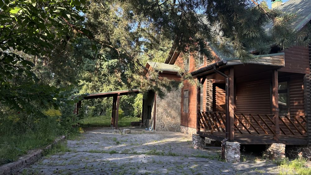 Козин, будинок біля річки в стилі шалє посеред дорослого ландшафту