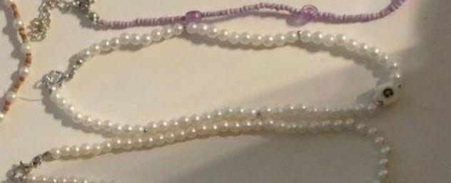 Naszyjnik perłowy z białym kwiatkiem.