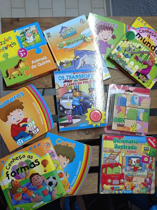 Livros  para criança, um puzzle cubo e uma bola saltitona