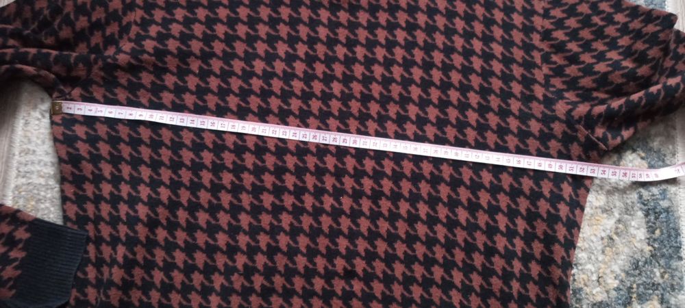 Bordowy sweter w czarną pepitkę.