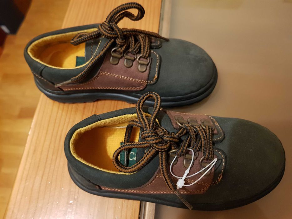 Sapatos novos de criança em pele
