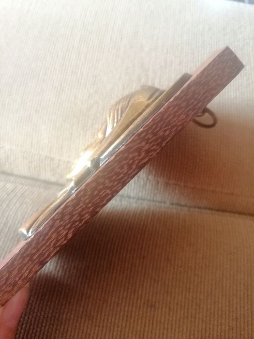 Quadro de madeira e metal com figura religiosa em alto-relevo