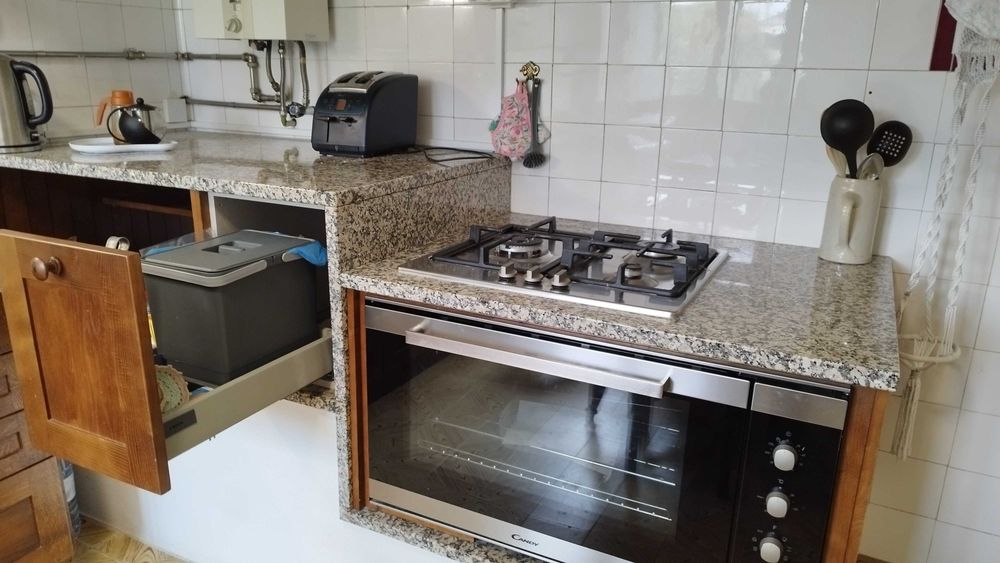 Conjunto de cozinha com bancada de mármore e madeira com forno e fogão