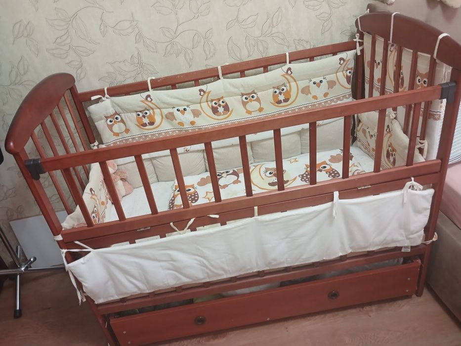 Дитяче ліжечко на маятнику з шухлядою, бортиками і постільною білизною