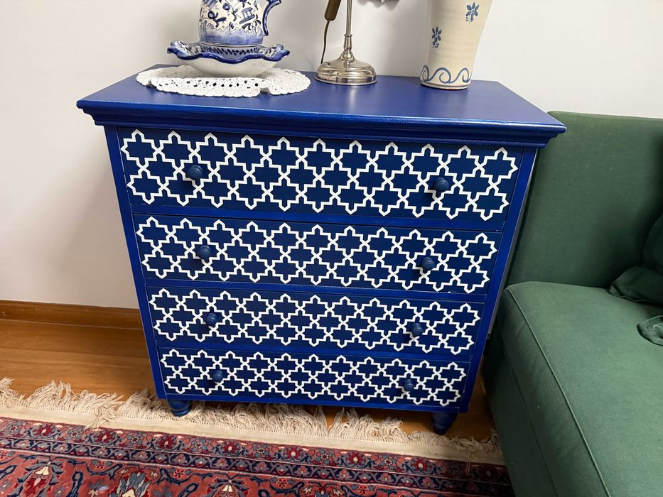 Comoda em madeira no tom azul com detalhes em branco.