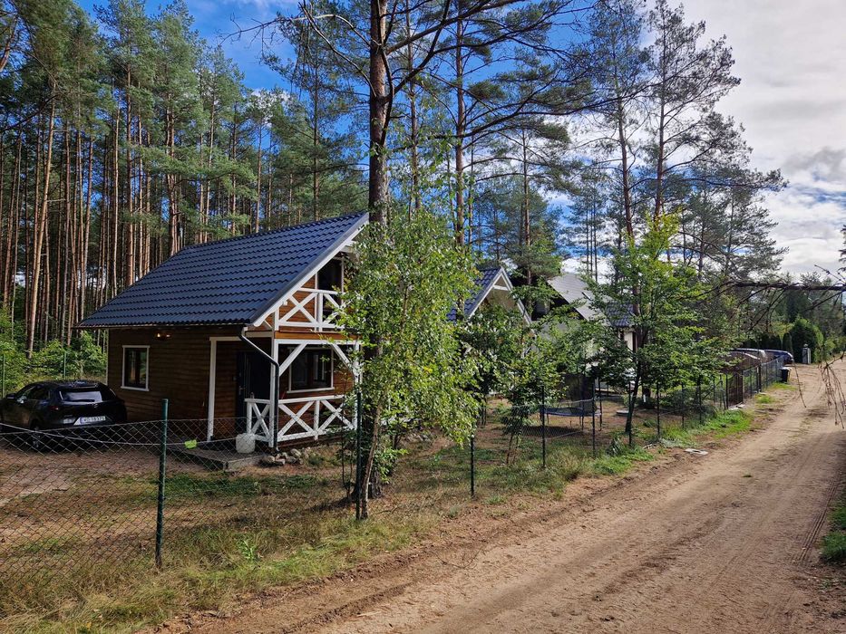 Domek w środku lasu nad jeziorem z jacuzzi na tarasie