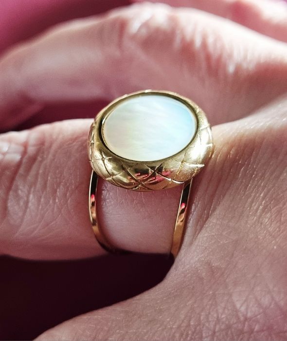 Anel dourado, em aço, com madrepérola redonda. Ajustável