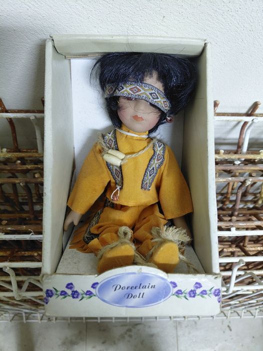 Boneca antiga de porcelana no estado real que se encontra nas fotos