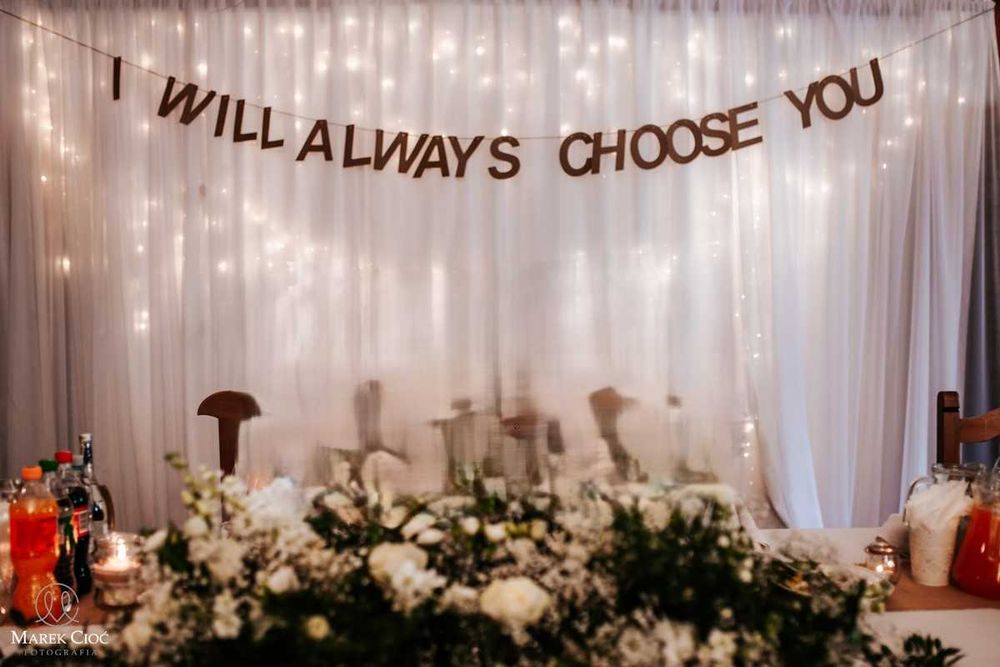 Napis na ściankę za Parą Młodą