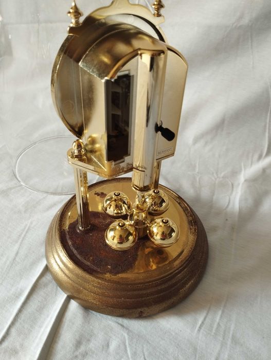 Relógio vintage de mesa sob cúpula de vidro, está a funcionar