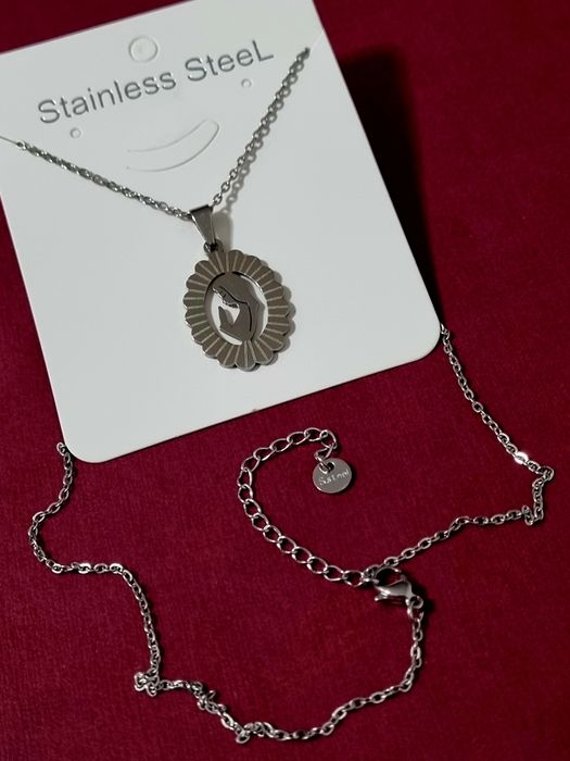 Colar prateado/dourado, em aço, com pingente da Nossa Senhora. Tem extensor