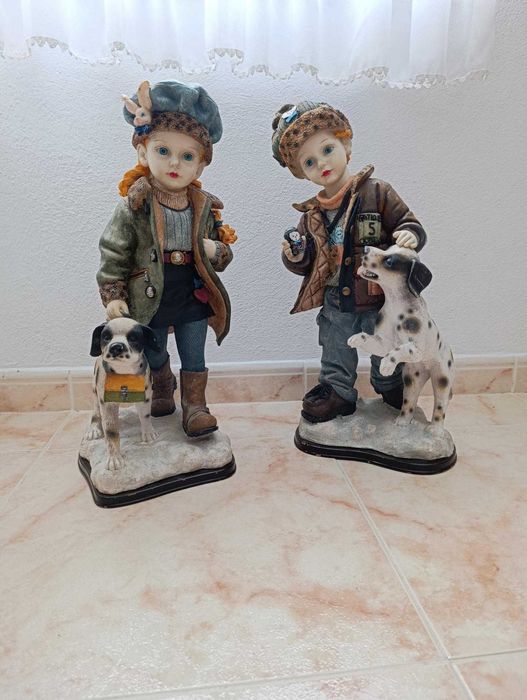 Par de estatuetas com crianças e o seu cão