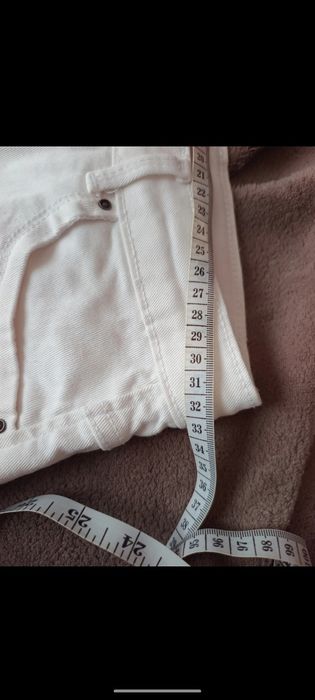 Białe strzępione spodenki