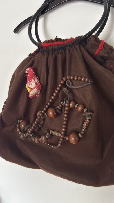 Mala de mão castanha com detalhes vermelhos
