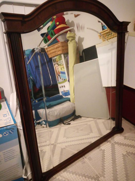 Espelho grande envolto em madeira