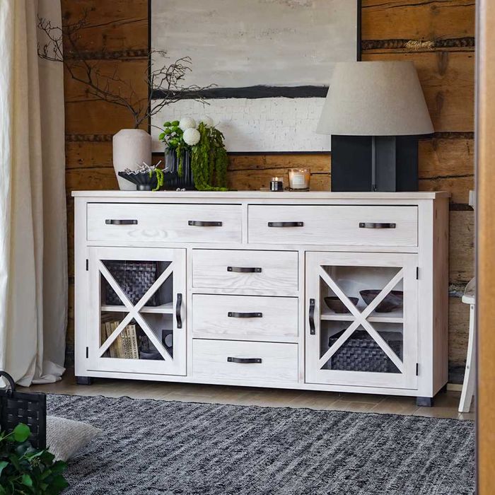 Biała komoda drewniana w stylu wiejskim, z krzyżykiem w drzwiach