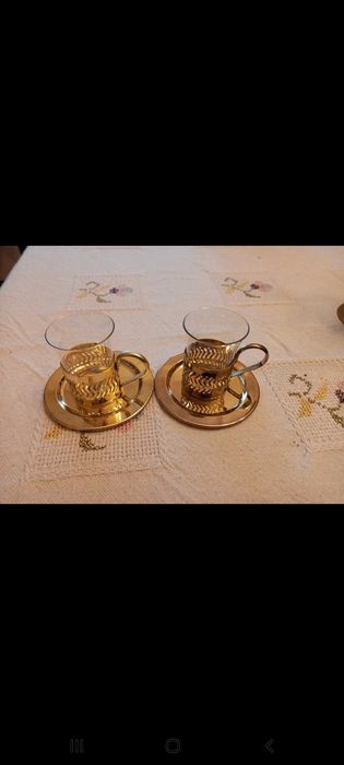 2 chávenas de vidro de café com apoio metálico dourado e Pires.