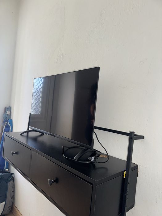 Estante preta pendurada para tv