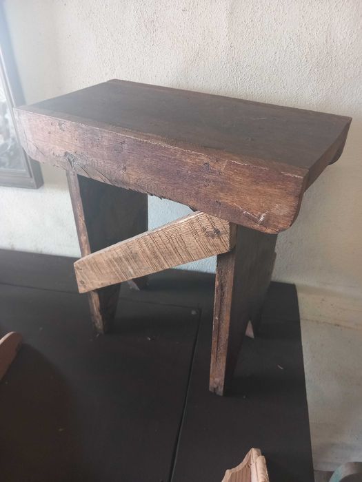 Banco de madeira antigo, conhecido em regiões como banco de ordenha ou banqueta de carpinteiro/ateliê.
