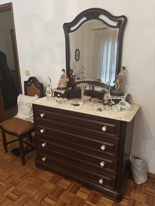 Cama de casal com mesas de cabeceira e cadeira