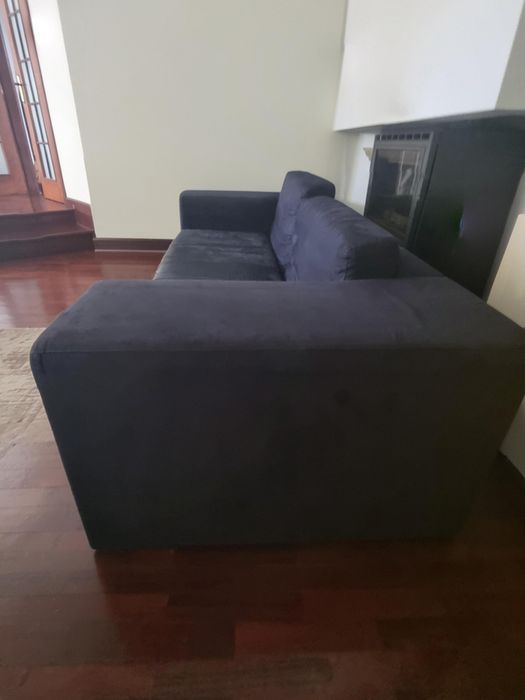 Vendo sofá preto usado, em bom estado geral e com um design simples e elegante.
