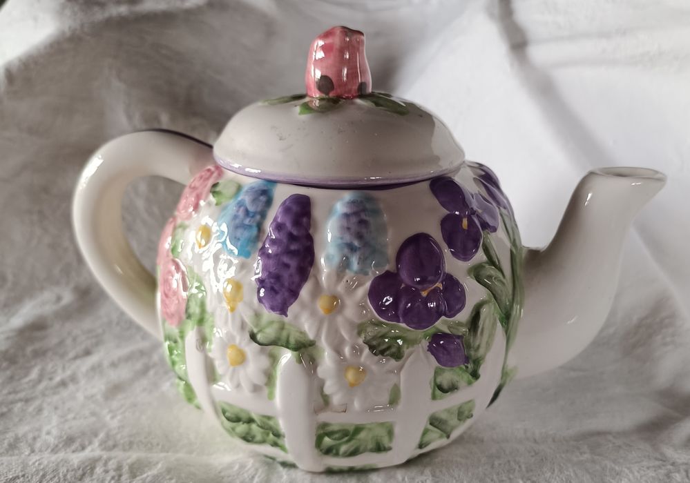 Bule em cerâmica pintado à mão com um padrão floral em relevo