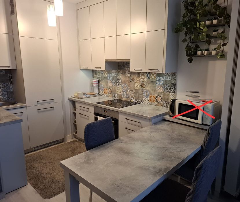 Zabudowa kuchenna ze stołem i sprzętem AGD