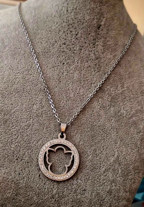 Colar prateado, em aço, pingente de anjinho rodeado de zirconias