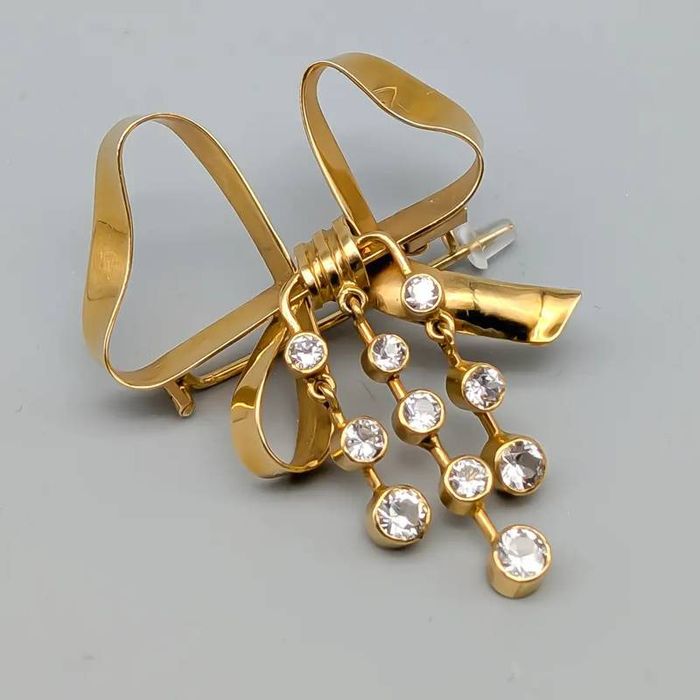 Broche em laço dourado com pedras brancas 18 quilates 7.09 gramas 45mm