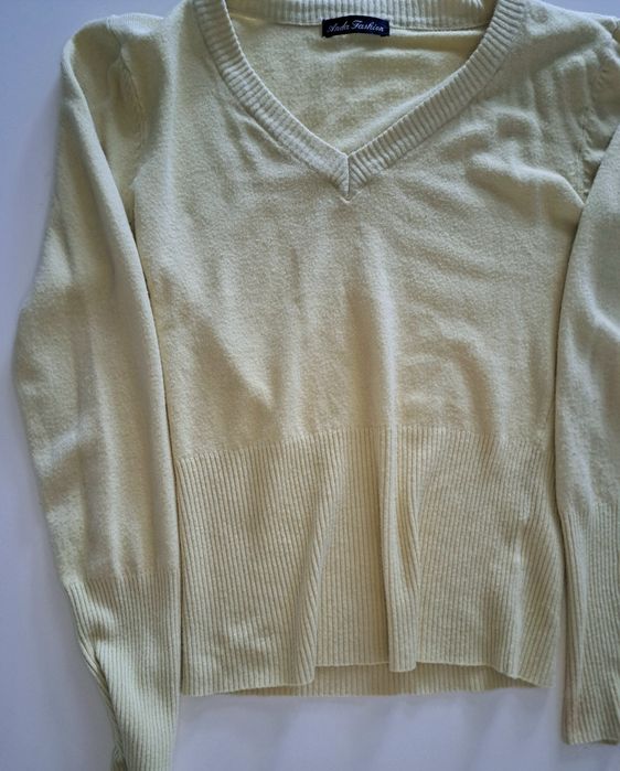 Żółty sweterek z długim rękawem.