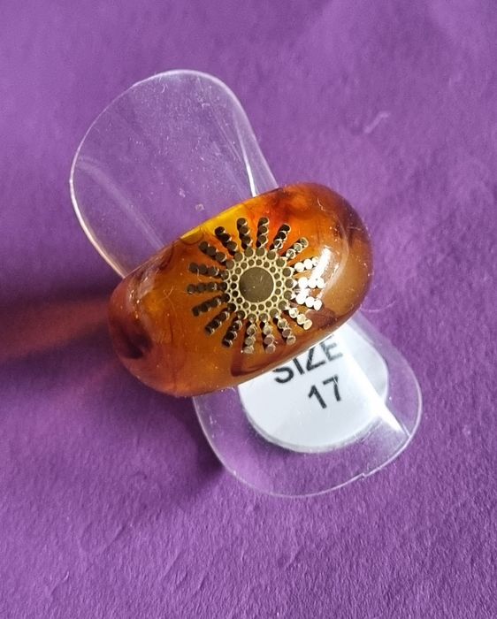 Anel em acrílico castanho com sol dourado, em aço. T17