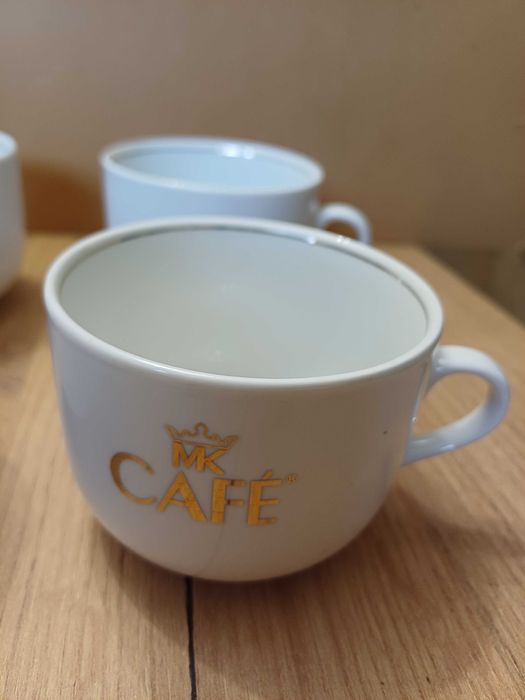 Komplet 4 filiżanek białych mc cafe ze złotym napisem i rantem