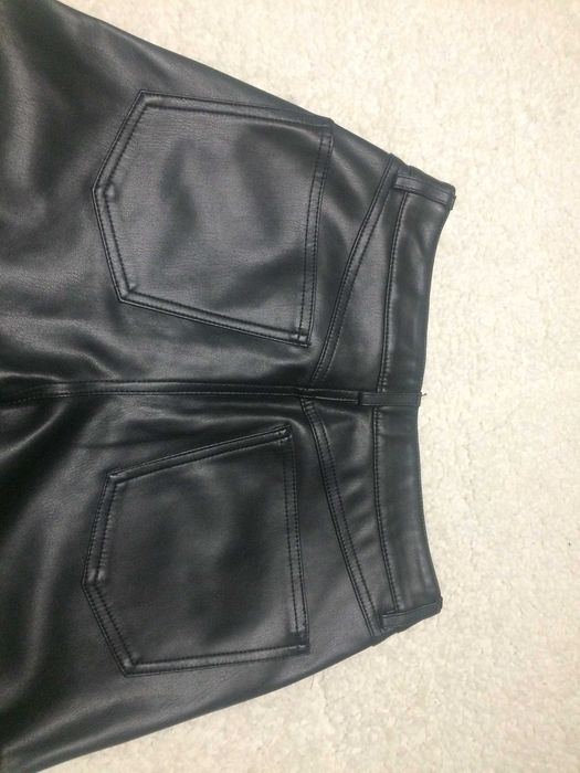 Calças imitação de pele pretas.