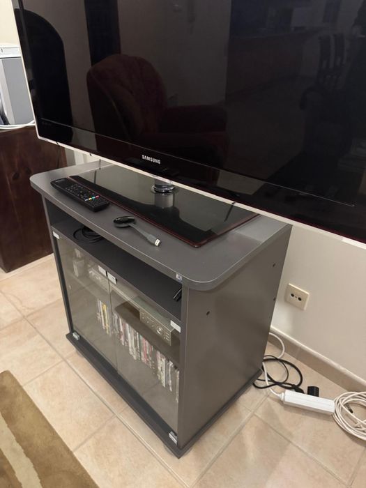 Móvel de TV cinzento com pés metalizados e portas de vidro