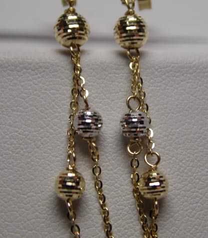 Złote wiszące kolczyki łańcuszki diamentowane dwukolorowe kulki.