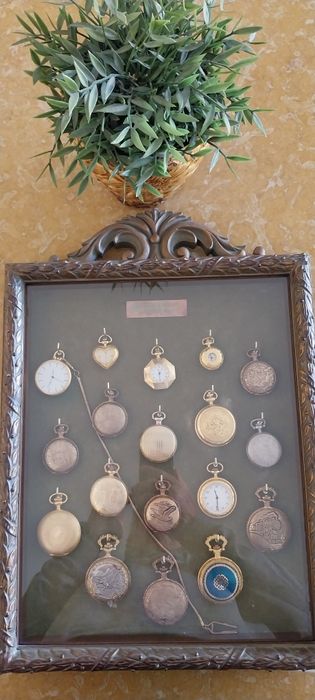 Quadro com 18 relógios de bolso.