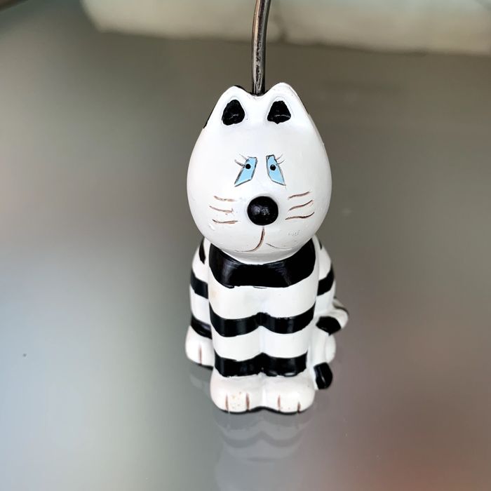 Pisa-papéis com aste vertical e três suportes magnéticos (gatos).