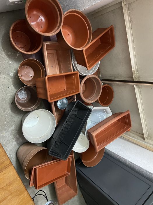 Conjunto composto por varios vasis e floreirasde plastico e a um vaso