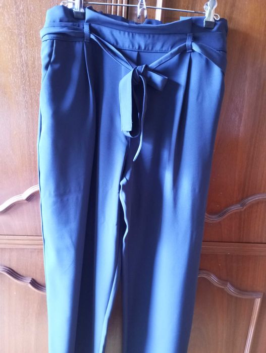 Calça azul escura, larga, com elástico e cinto na cintura