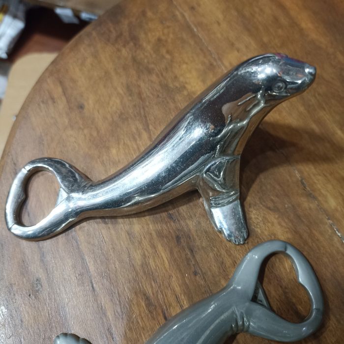 Abre-capsulas em inox, figura de animais marinhos.