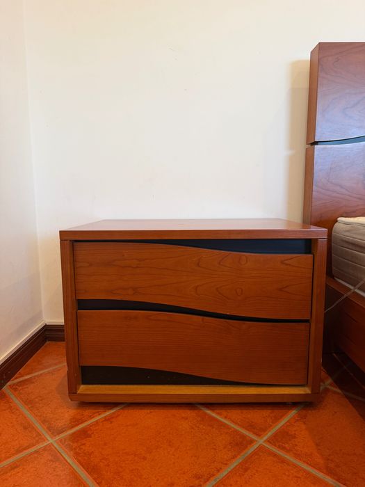 Uma cama com 2 mesinhas de cabeceiras e uma cómoda