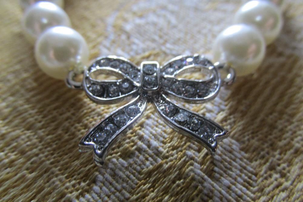 Pulseira de pérolas e laço