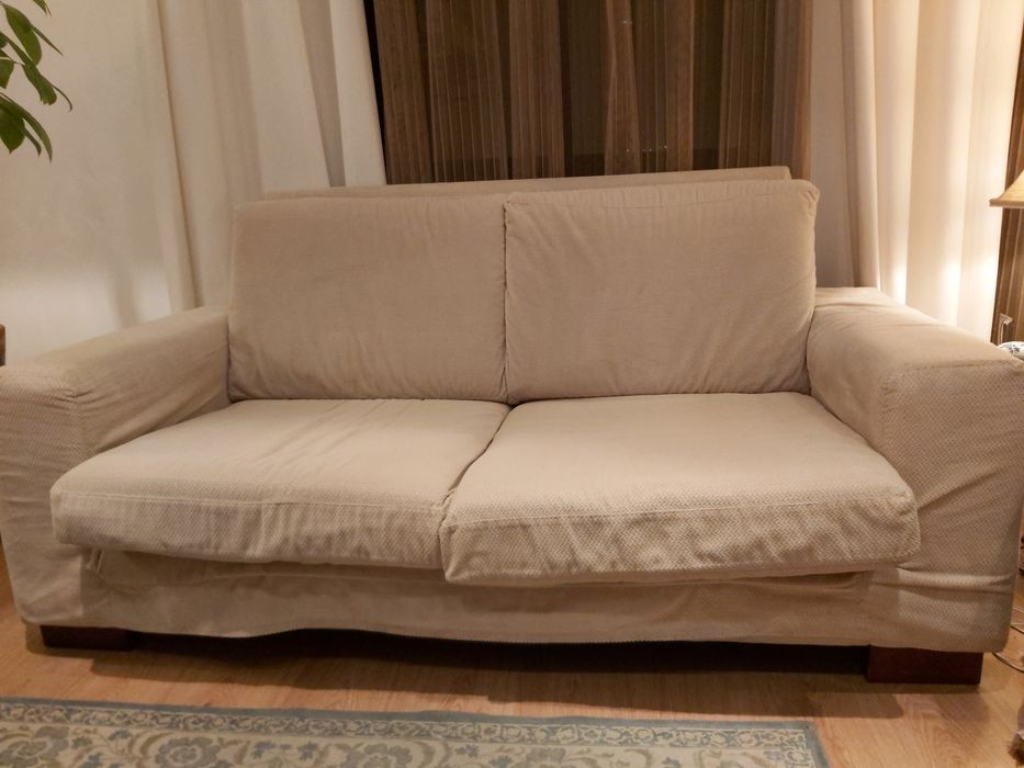 Sofá de 2 lugares com pés de madeira.