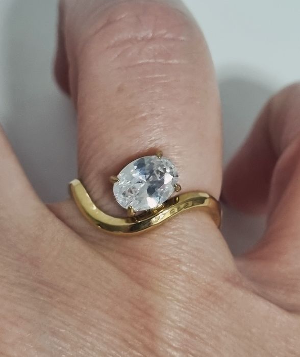 Anel dourado, em aço, muito diferente e com um ponto de luz oval. Ajustável