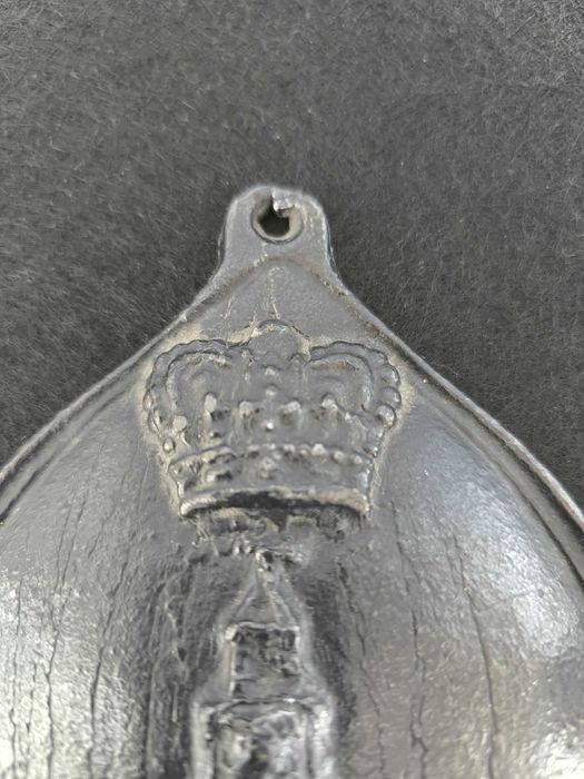 Placa de metal com o n.º 754398, marcada com o emblema da seguradora