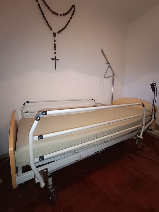 Cama articulada hospitalar com colchão, cadeira de rodas e muletas