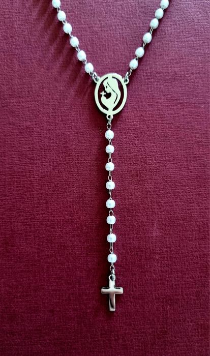 Colar prateado, em aço, em forma de terço com pequenas pérolas.